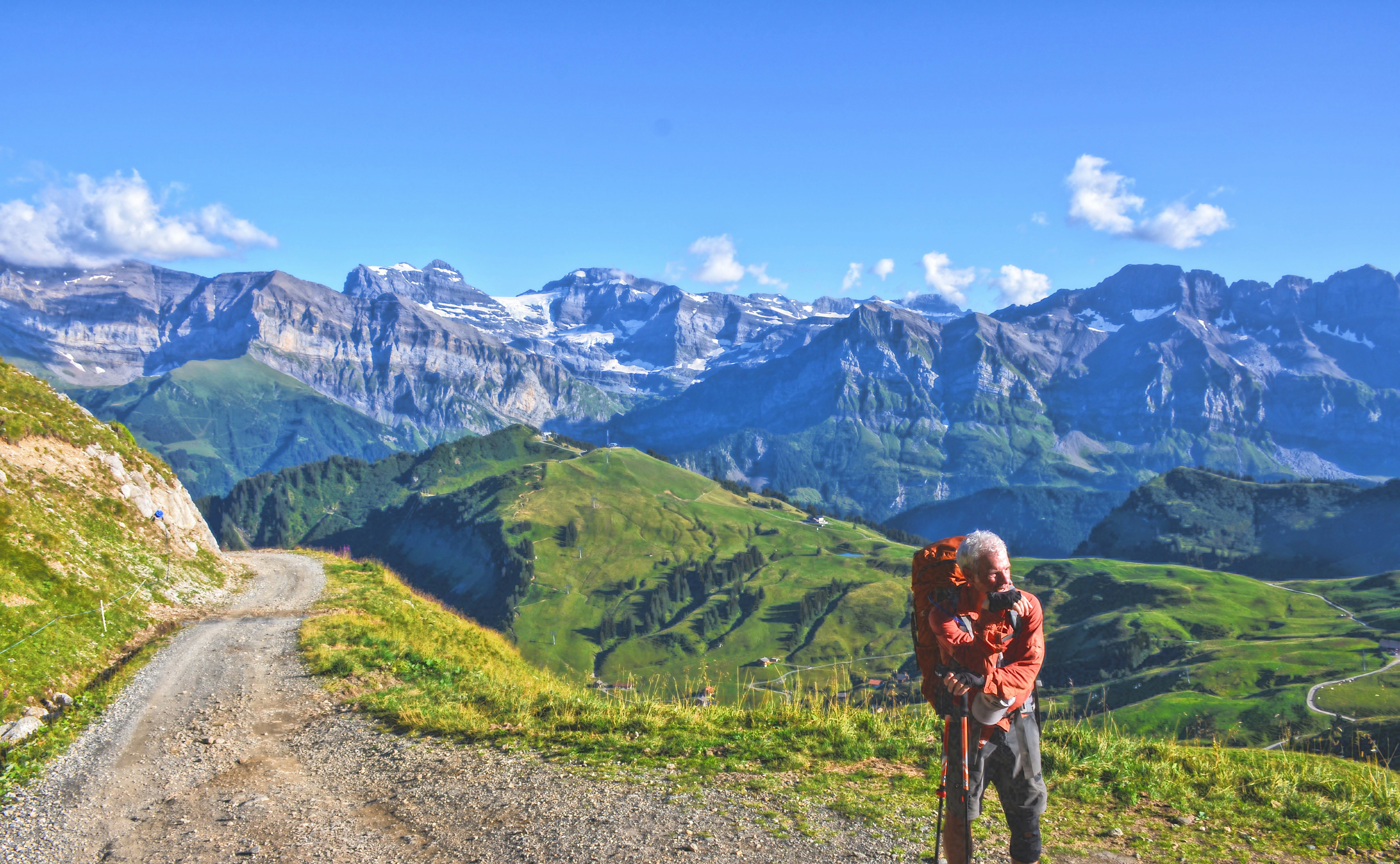 man standing far away from mountains